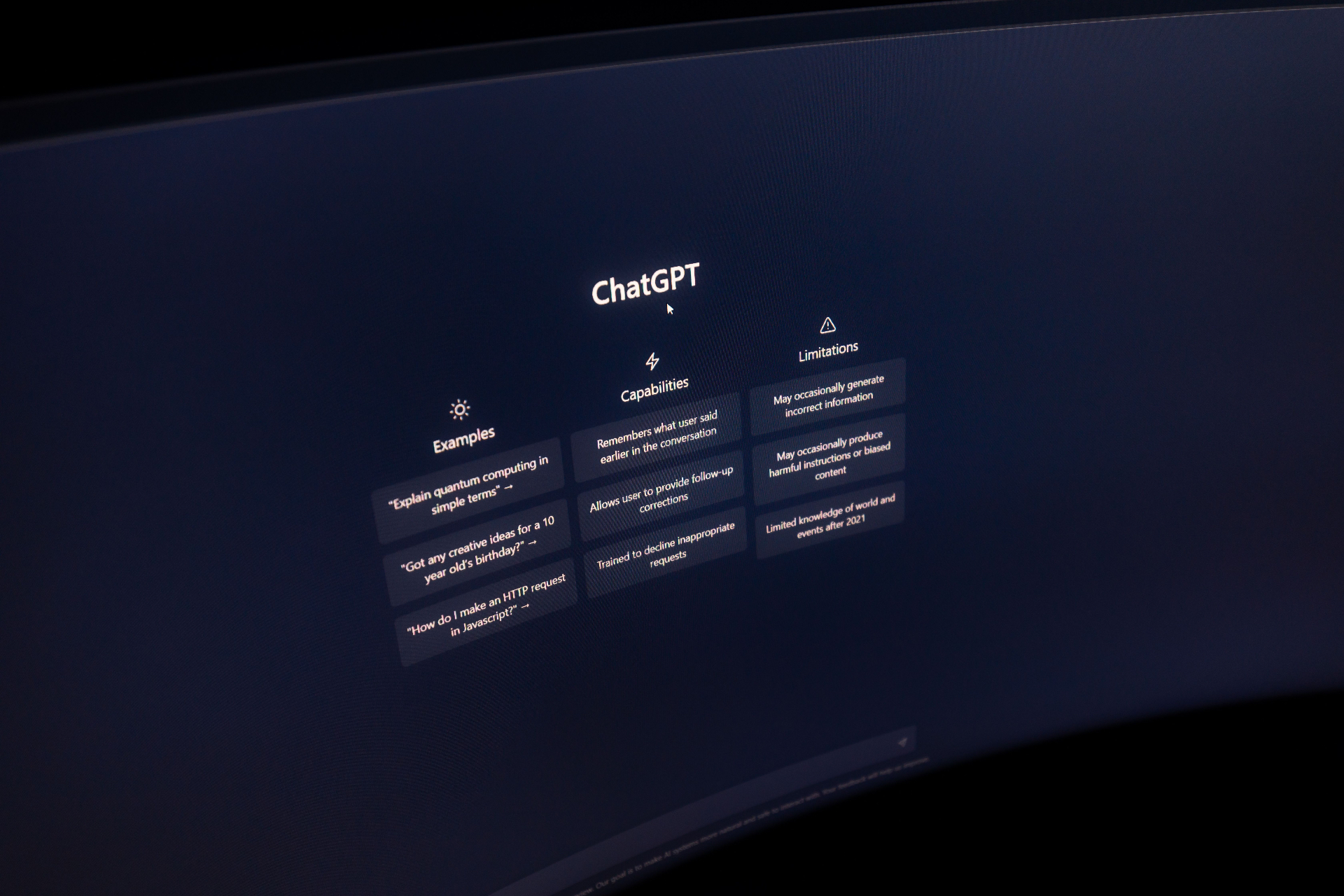Close-up of a curved monitor displaying a ChatGPT interface in a dark room